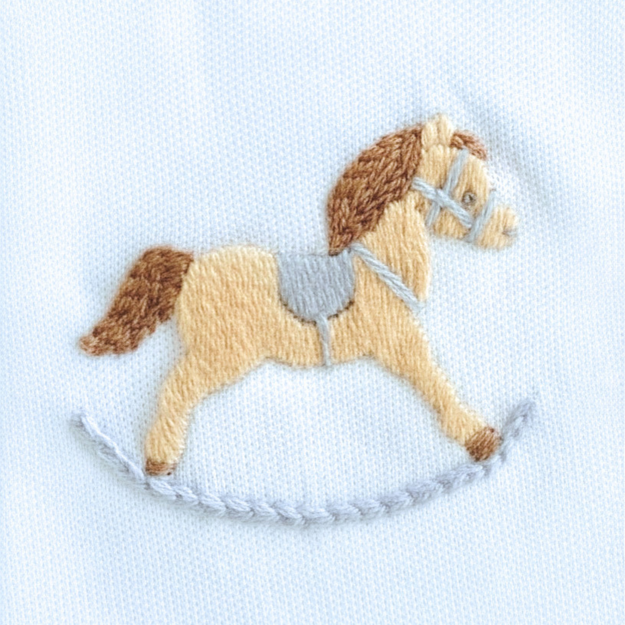 Embroidered rocking horse on a light blue background
